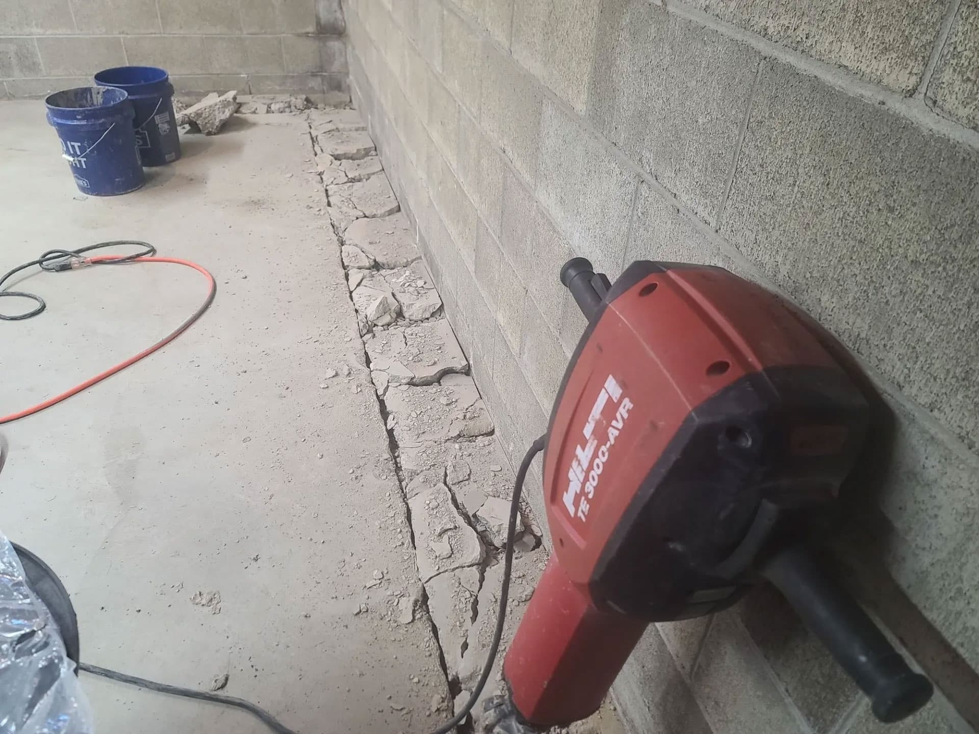 Hilti rotary hammer breaking out basement concrete for a new drainage trench