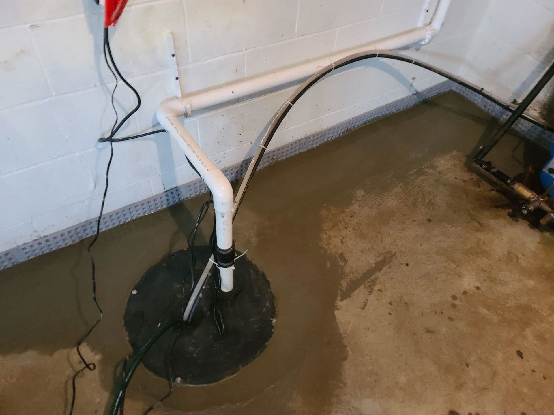 Newly installed sump pump with airtight cover, PVC discharge line and battery backup wiring